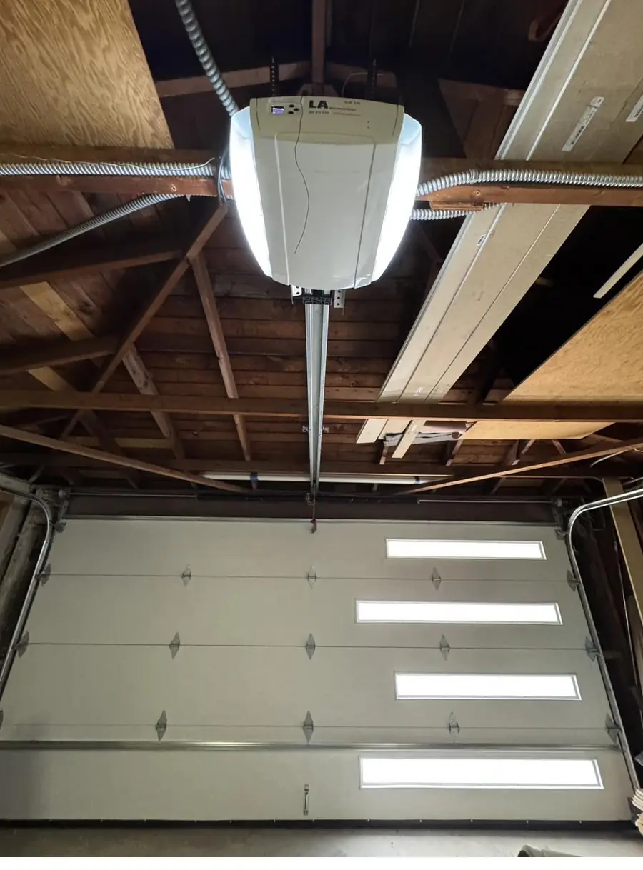 Belt-drive garage door opener mounted over a door with window panels