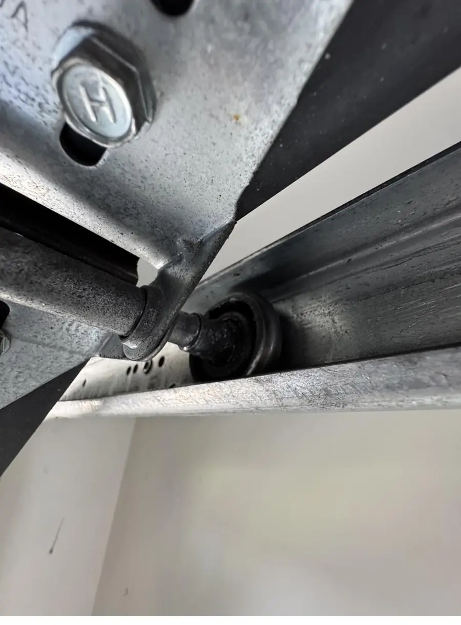 Garage door track and roller bracket, realigned after the door came off track